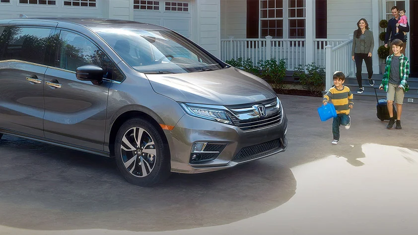 Family exiting their house heading towards a Honda Odyssey